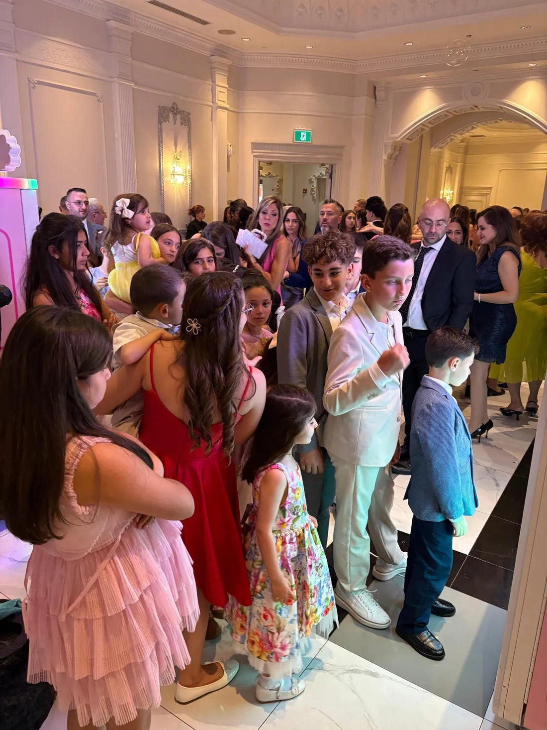 Guests in formal wear gather and line up at a banquet hall celebration